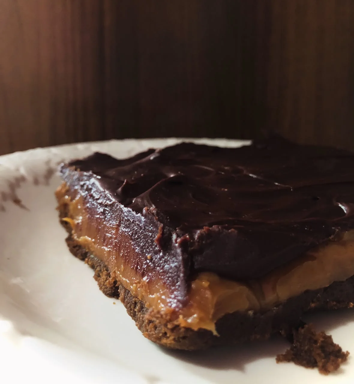 Fatia da torta escocesa amanteigada com camadas de chocolate e caramelo